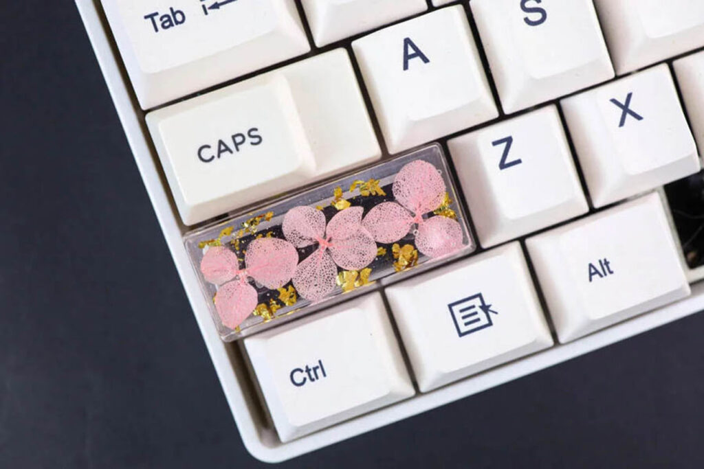 The combination of dried flowers, gold flakes, and clear resin in Hirosart's design creates visually appealing girly keycaps