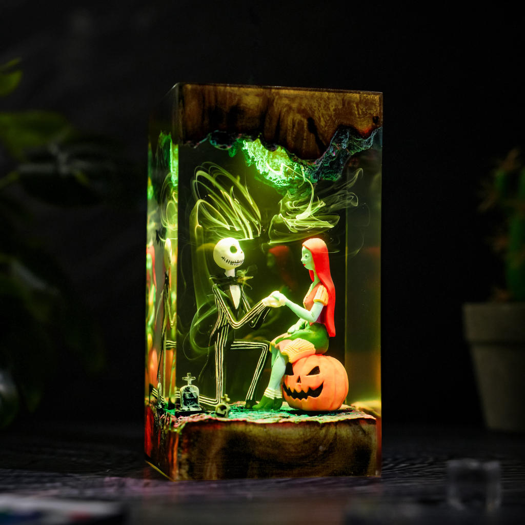 Jack Skellington and Sally Halloween lamp - front view with green LED glow, a carved pumpkin, and a clear resin body